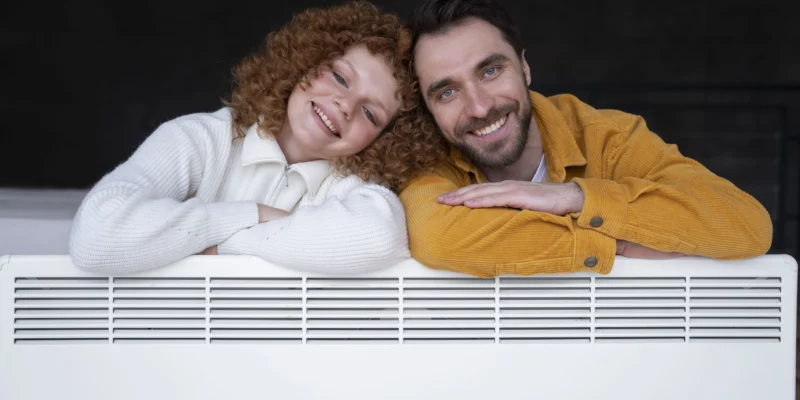 Posierendes Pärchen über einer Elektroheizung