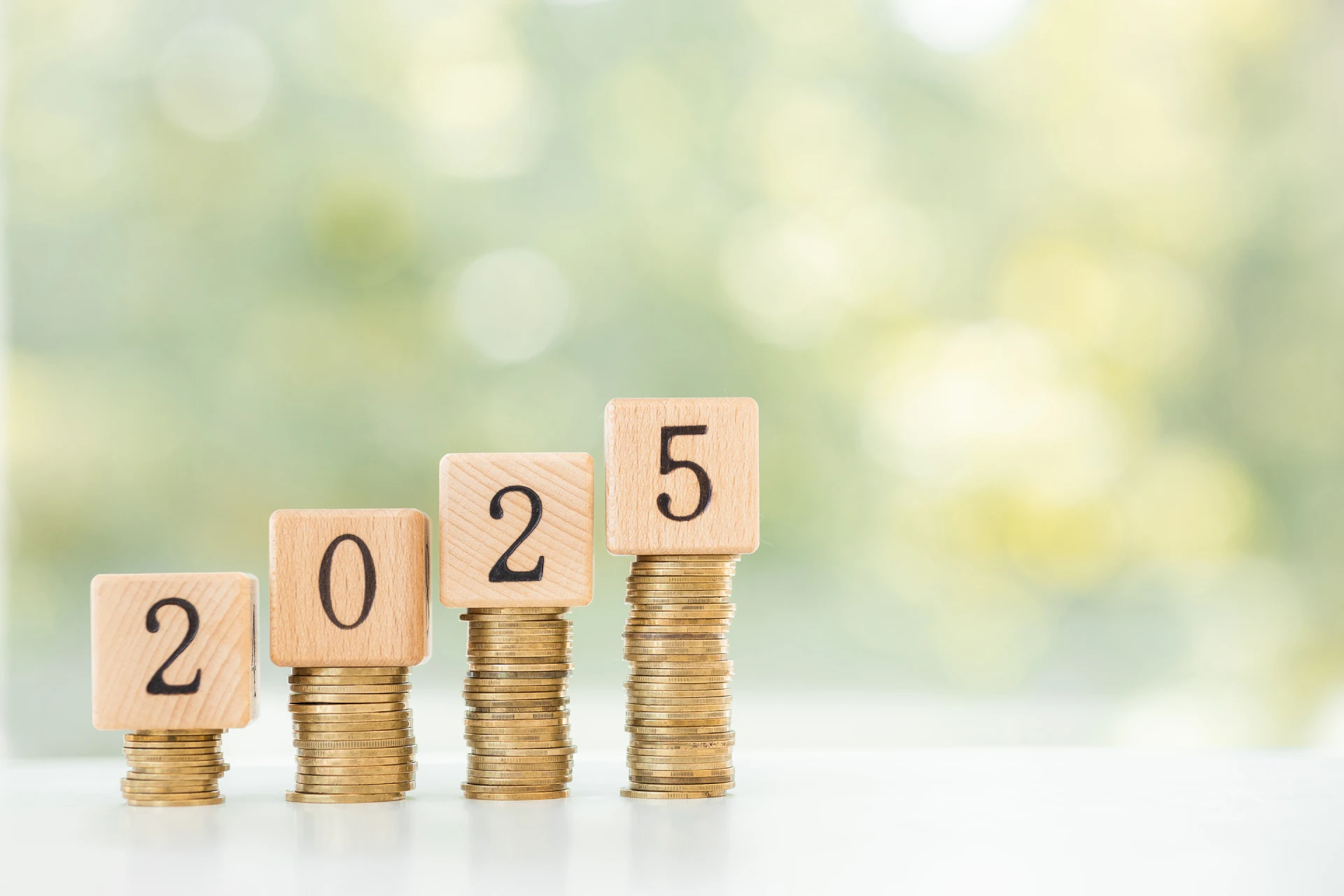 Ein Bild, das steigende Stapel von Münzen zeigt, gekrönt von Holzklötzen, die zusammen das Jahr 2025 ergeben. Dies symbolisiert Wachstum oder positive finanzielle Entwicklung im Kontext der Einspeisevergütung 2025.